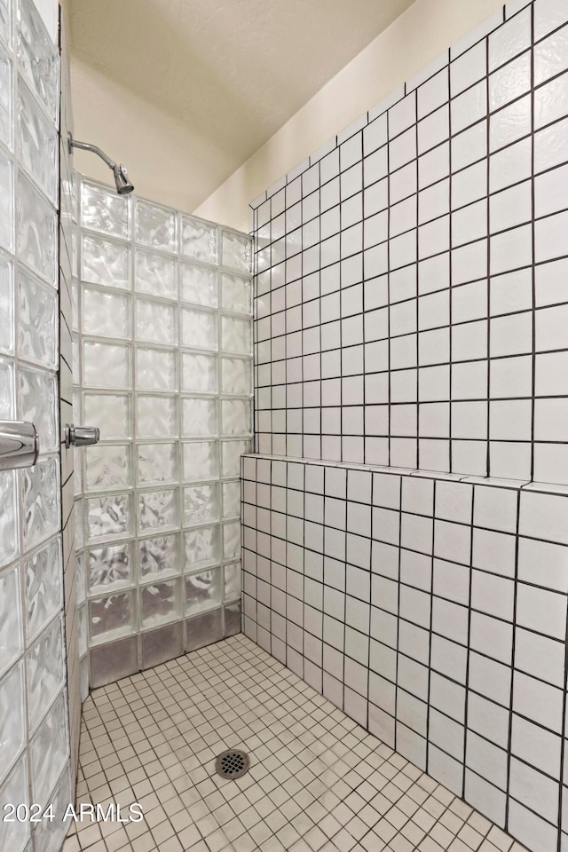 bathroom with a tile shower and tile patterned floors