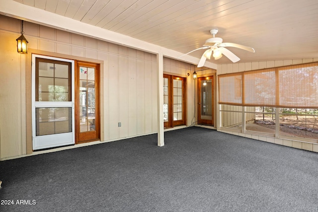 unfurnished sunroom with ceiling fan, wooden ceiling, and french doors