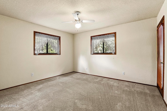 empty room with light carpet, ceiling fan, and a textured ceiling