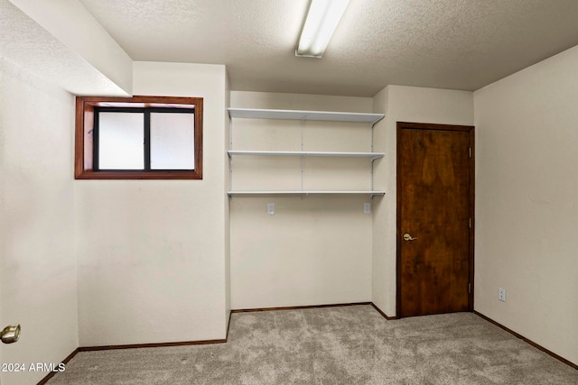 unfurnished bedroom with light carpet, a closet, and a textured ceiling