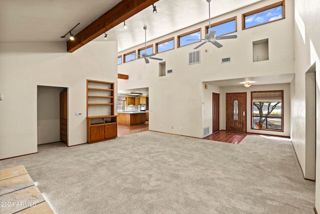 unfurnished living room featuring carpet floors, beamed ceiling, high vaulted ceiling, and rail lighting