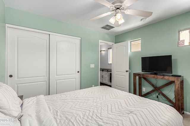 carpeted bedroom with ceiling fan and a closet