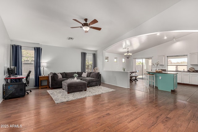 living room with lofted ceiling, a healthy amount of sunlight, and dark hardwood / wood-style flooring