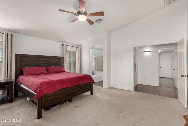 bedroom featuring vaulted ceiling, light colored carpet, ceiling fan, and connected bathroom