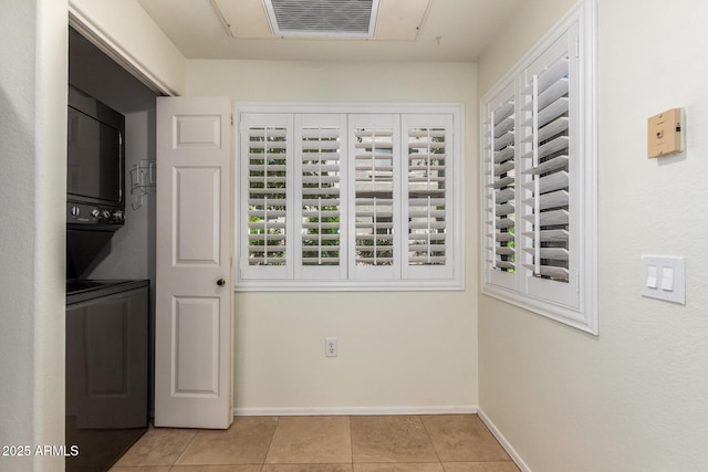 9455 E Raintree Dr Unit 1025, Scottsdale, AZ 85260 - laundry room featuring stacked washing machine and dryer, baseboards, and tile patterned flooring