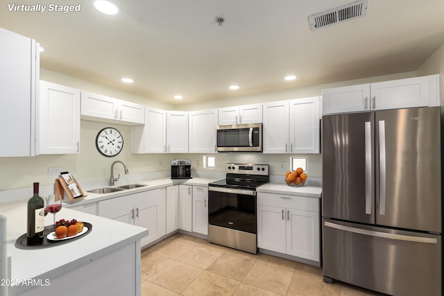 9455 E Raintree Dr Unit 1025, Scottsdale, AZ 85260 - kitchen featuring appliances with stainless steel finishes, a sink, light countertops, light tile patterned flooring, and white cabinetry
