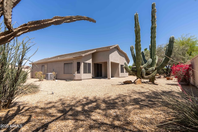 rear view of property featuring stucco siding and central AC unit