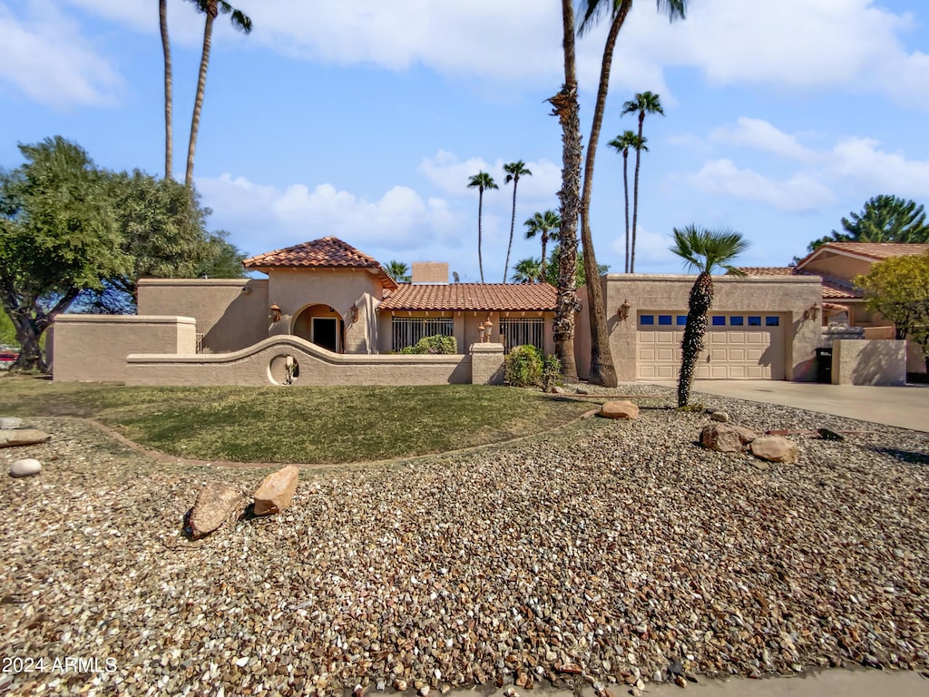 mediterranean / spanish home featuring a tiled roof, a garage, stucco siding, and driveway