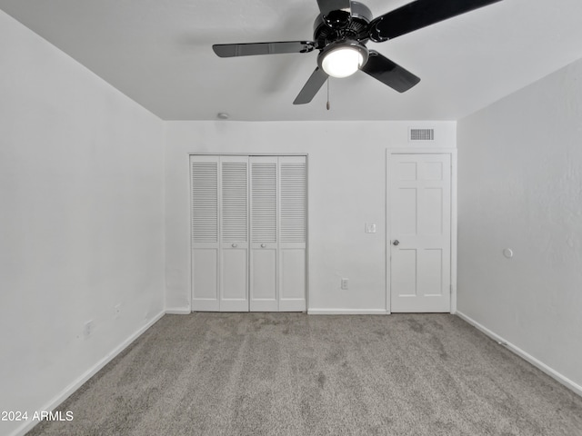 unfurnished bedroom featuring light carpet, a closet, and ceiling fan