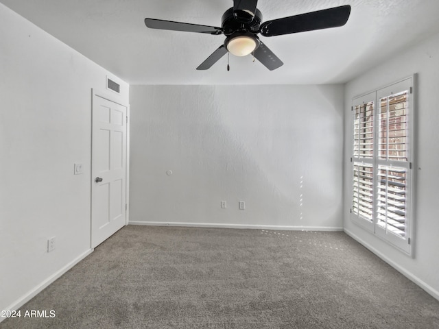 empty room with ceiling fan and carpet floors