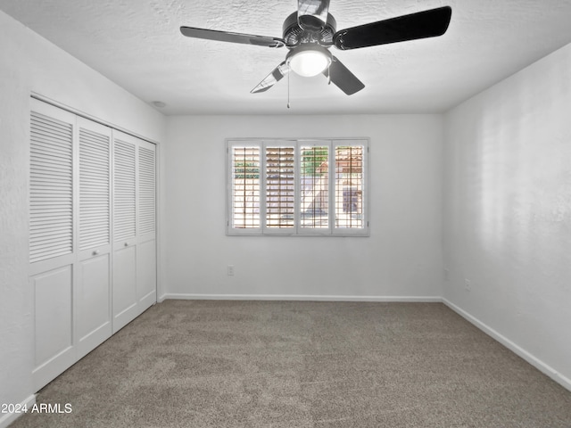 unfurnished bedroom with ceiling fan, carpet floors, a closet, and a textured ceiling