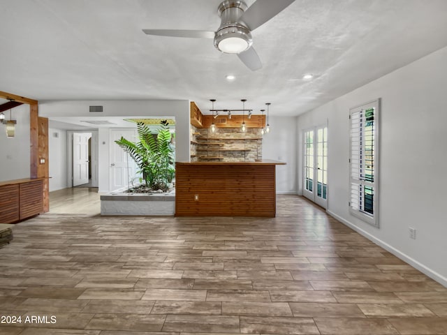 unfurnished living room with ceiling fan and light hardwood / wood-style floors