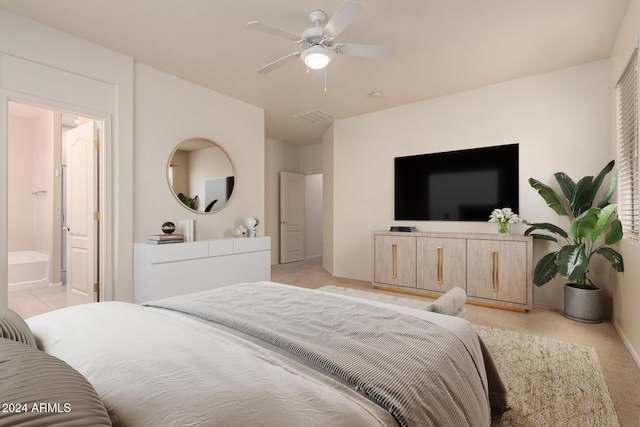 bedroom featuring ceiling fan, connected bathroom, and light carpet