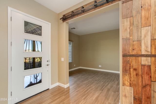 foyer with light hardwood / wood-style floors and a barn door