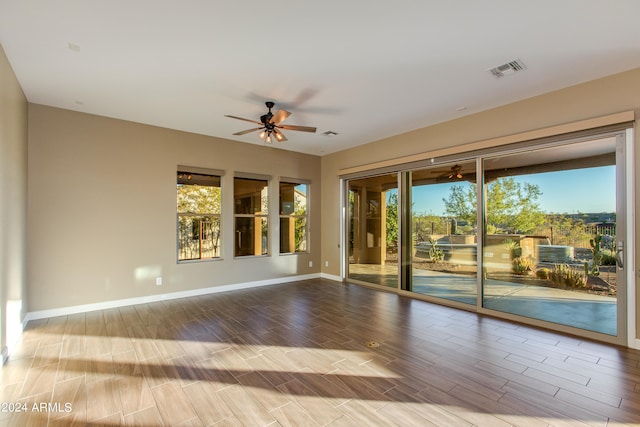 empty room with hardwood / wood-style flooring, plenty of natural light, and ceiling fan