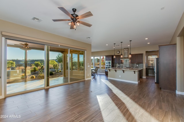 unfurnished living room featuring sink, dark hardwood / wood-style floors, and ceiling fan