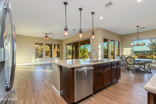 kitchen featuring sink, hanging light fixtures, stainless steel appliances, and plenty of natural light