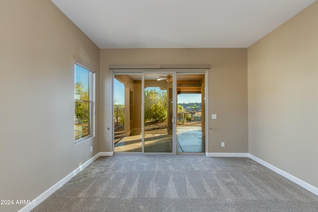 carpeted spare room with ceiling fan and a wealth of natural light