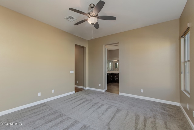 unfurnished bedroom featuring connected bathroom, ceiling fan, and light carpet