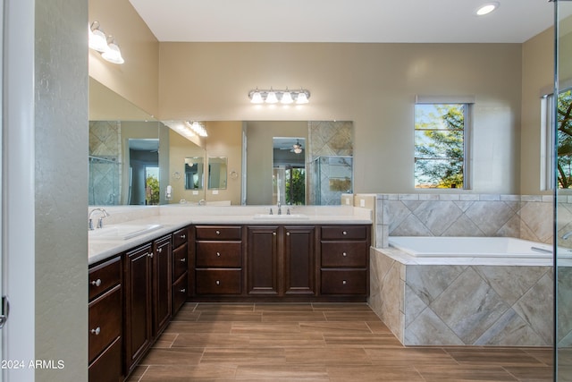 bathroom with vanity, wood-type flooring, and shower with separate bathtub