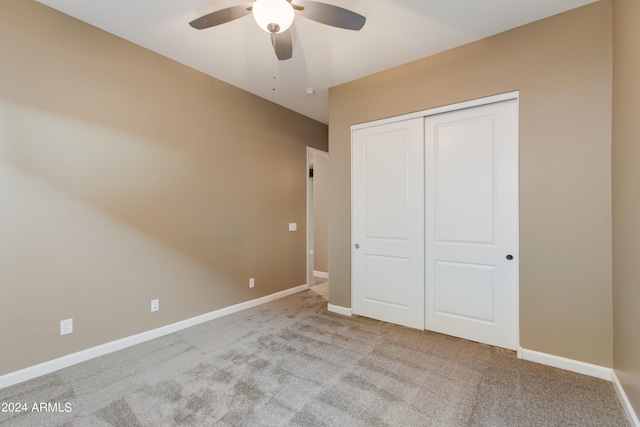 unfurnished bedroom featuring a closet, ceiling fan, and light colored carpet