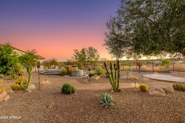 yard at dusk featuring a patio and a jacuzzi