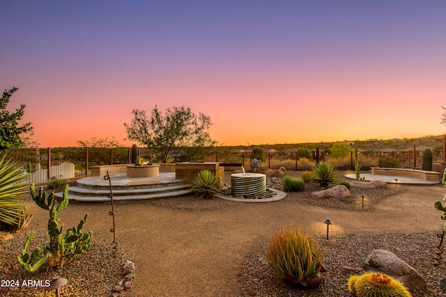 yard at dusk featuring a patio