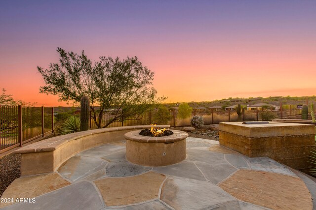 patio terrace at dusk featuring an outdoor fire pit