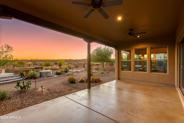 patio terrace at dusk featuring cooling unit and ceiling fan