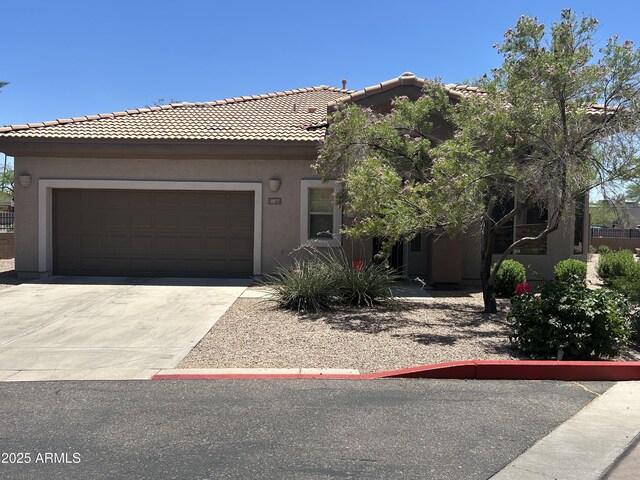 14000 N 94th St Unit 1077, Scottsdale, AZ 85260 - view of front facade with stucco siding, a tiled roof, an attached garage, and concrete driveway