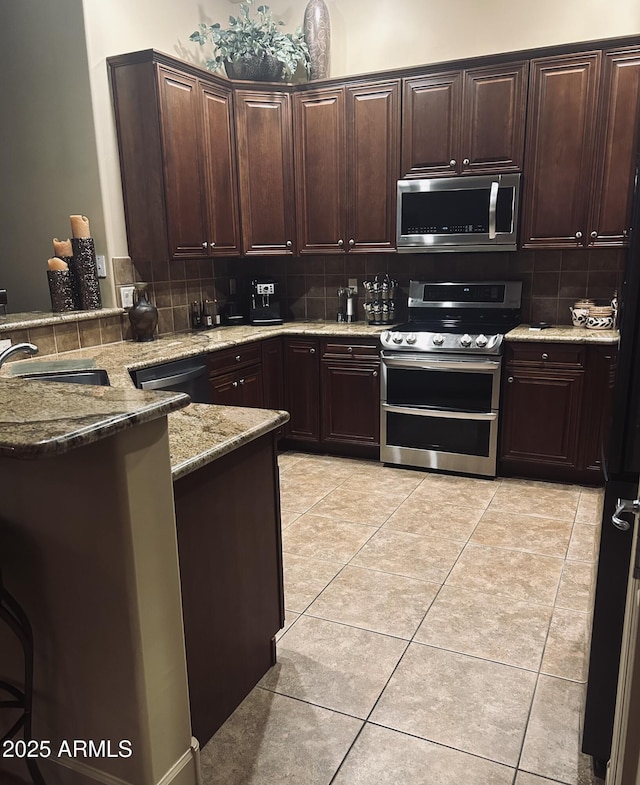 14000 N 94th St Unit 1077, Scottsdale, AZ 85260 - kitchen with appliances with stainless steel finishes, backsplash, a peninsula, and light stone counters