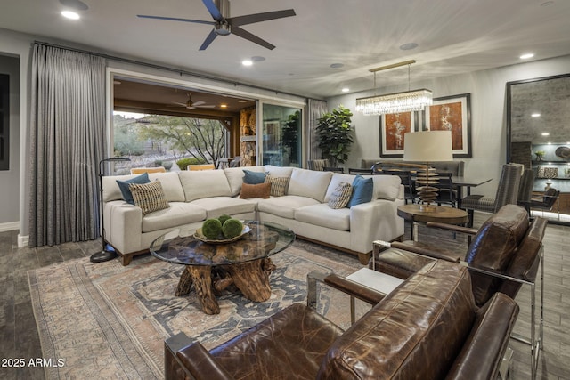 living room with ceiling fan with notable chandelier