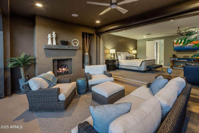 carpeted bedroom with ceiling fan and a fireplace