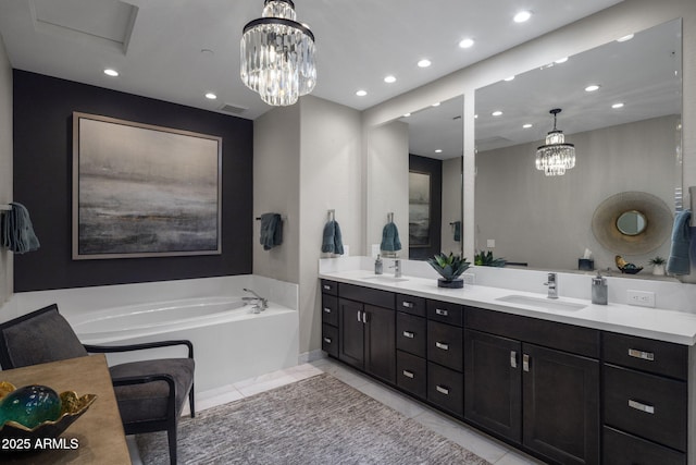 bathroom with tile patterned flooring, vanity, a tub, and an inviting chandelier