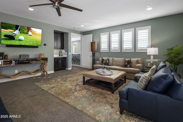 carpeted living room with sink and ceiling fan