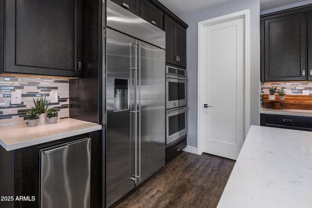 kitchen featuring appliances with stainless steel finishes, dark hardwood / wood-style floors, and backsplash