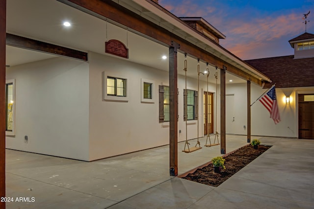 exterior entry at dusk featuring a patio area