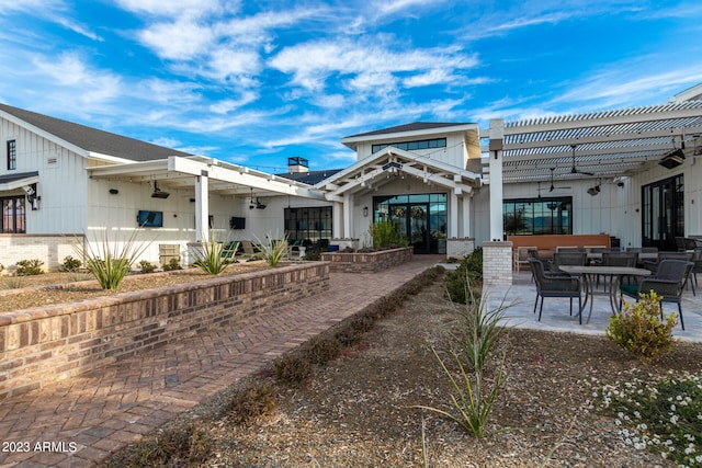 rear view of property featuring a pergola and a patio