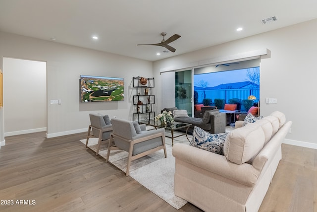 living room with light hardwood / wood-style floors and ceiling fan