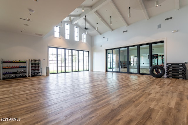 interior space with wood-type flooring, high vaulted ceiling, french doors, and beam ceiling