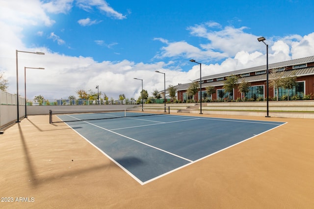 view of tennis court featuring basketball hoop