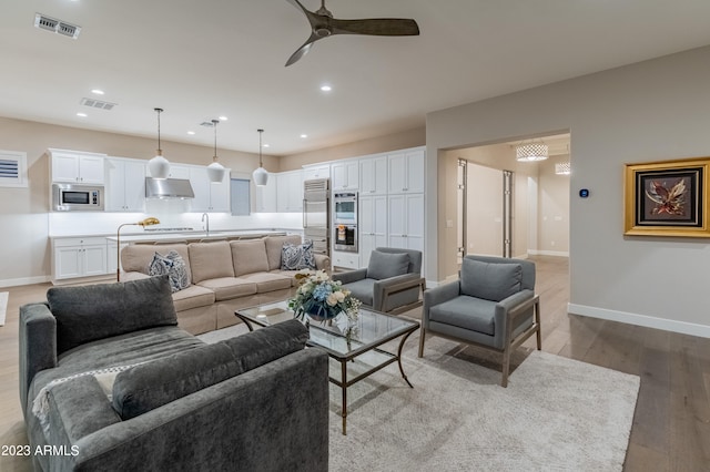 living room featuring light hardwood / wood-style floors and ceiling fan