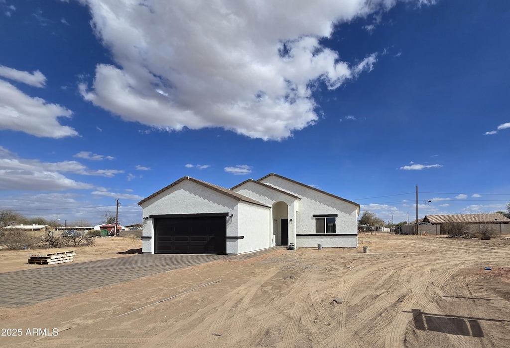 view of front of property with stucco siding, decorative driveway, and a garage