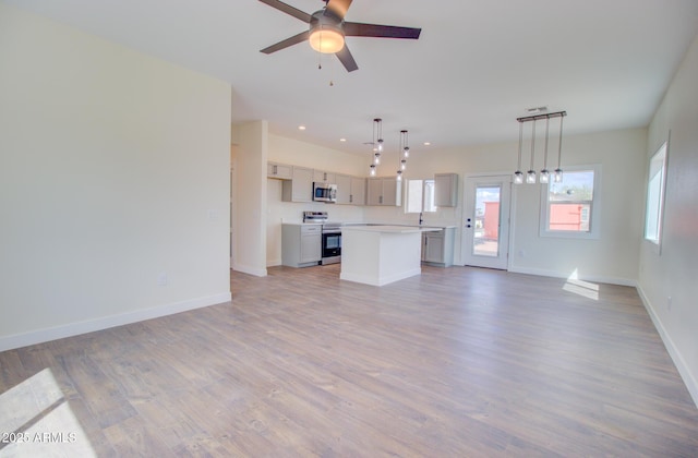 4115 N Monarch Dr, Eloy, AZ 85131 - unfurnished living room with light wood finished floors, ceiling fan, baseboards, and recessed lighting