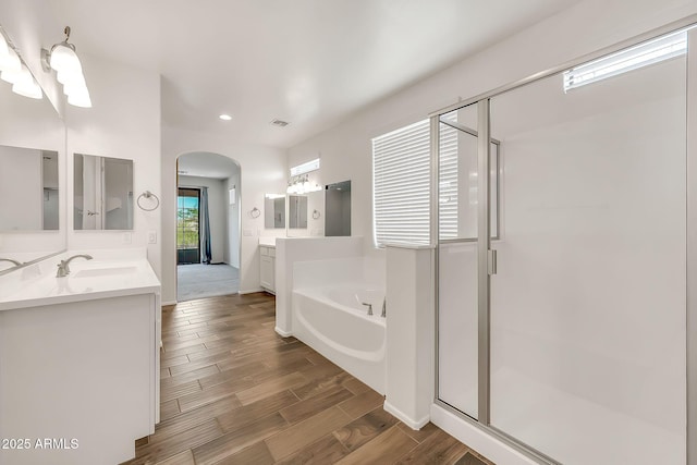 9017 E June Cir, Mesa, AZ 85207 - full bathroom featuring a bath, a shower stall, wood finished floors, two vanities, and recessed lighting