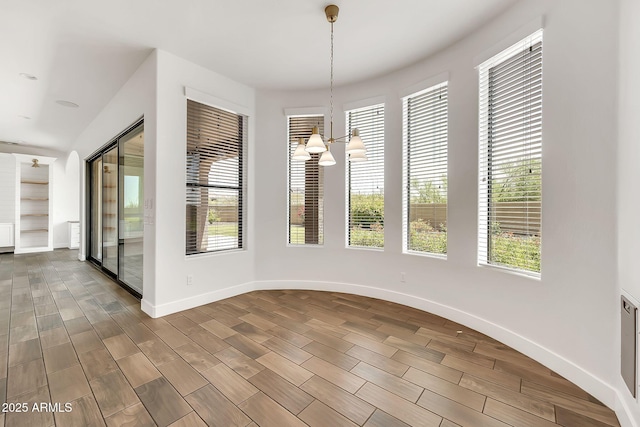 9017 E June Cir, Mesa, AZ 85207 - unfurnished dining area featuring baseboards, dark wood-style floors, healthy amount of natural light, and a chandelier