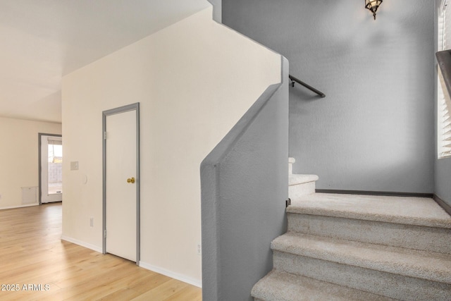 stairs with baseboards and wood finished floors