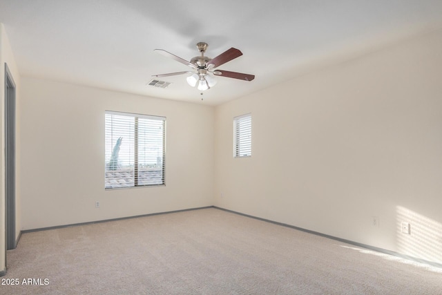 unfurnished room with light carpet, visible vents, baseboards, and ceiling fan