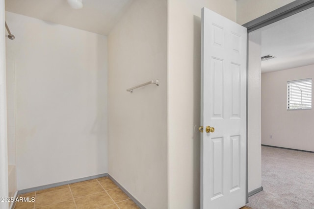 interior space with visible vents, light carpet, baseboards, and light tile patterned flooring