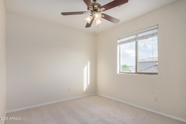 carpeted empty room with visible vents, baseboards, and a ceiling fan